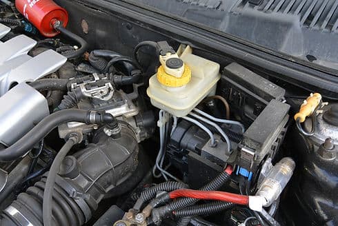Engine bay with the brake-fluid reservoir and battery visible, hood up.